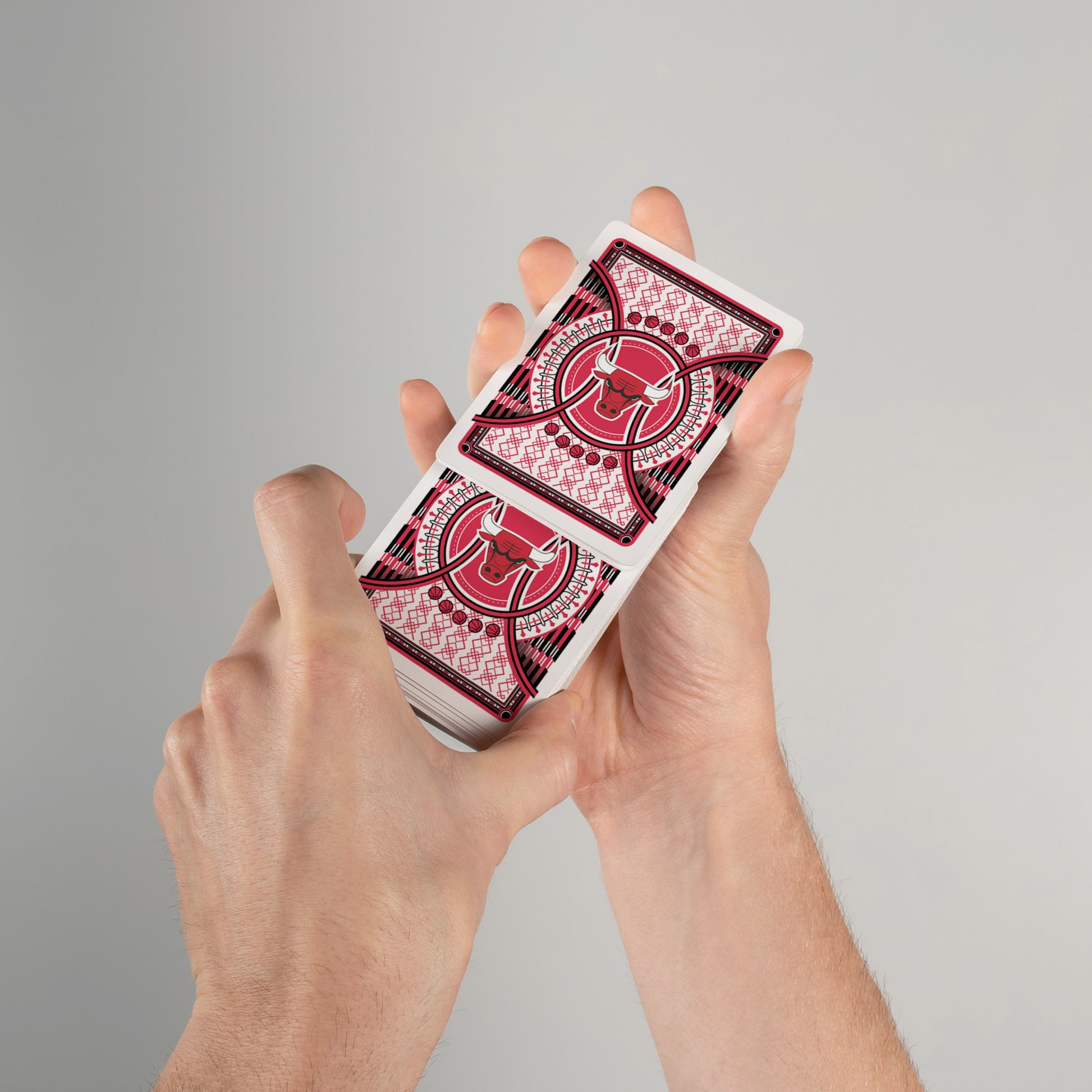 Person shuffling Bulls-themed playing cards with custom design on card backs