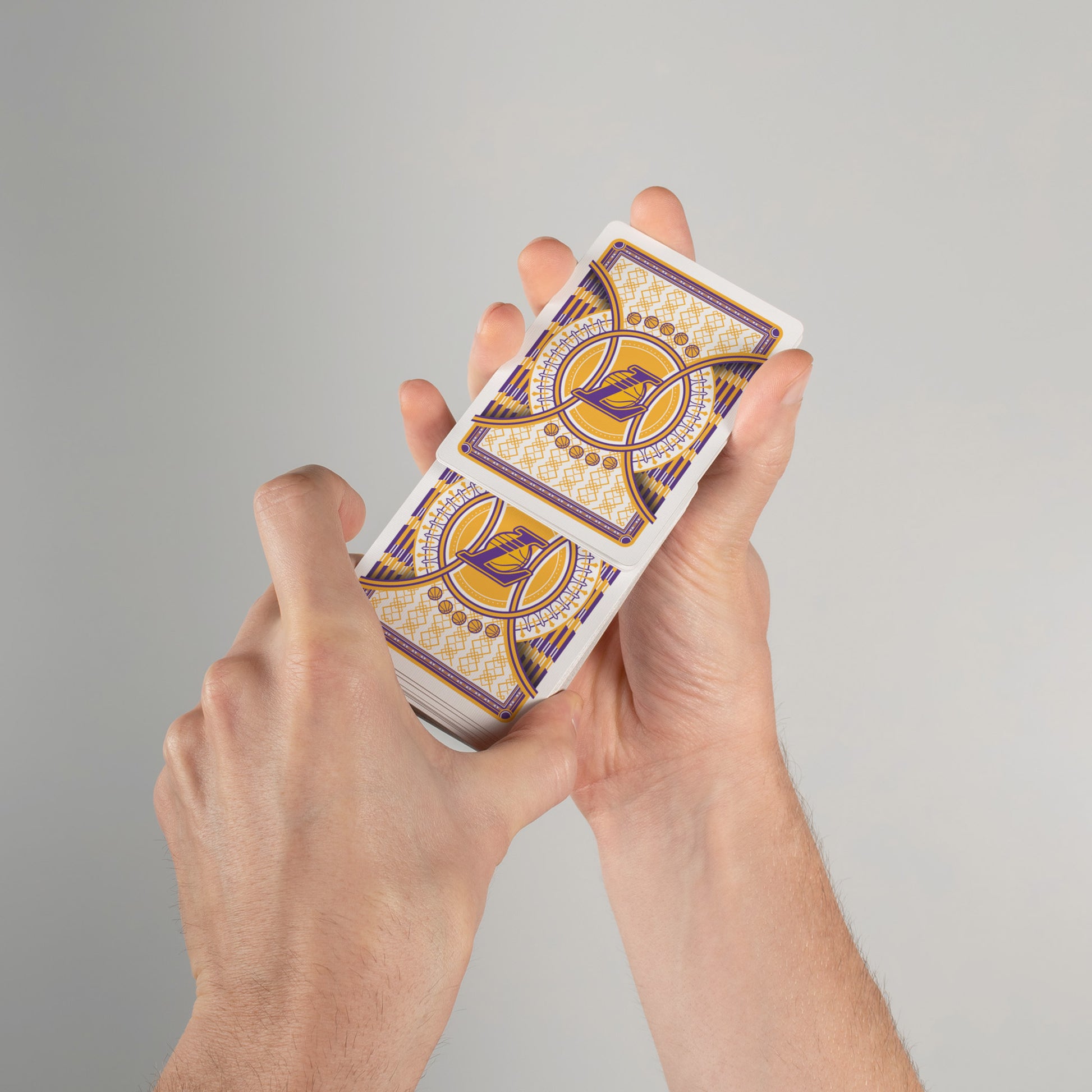 Person shuffling Lakers-themed playing cards with custom design on card backs